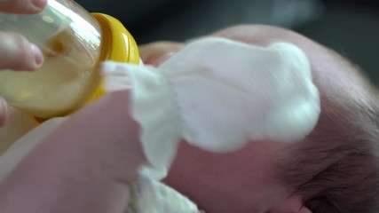 Baby refusing to drink the bottle formula milk that mother feeding,  Infant refuses a bottle and struggling. Baby does not want to eat, refuses the bottle.