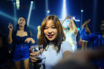 young asian woman in nightclub with colorful light