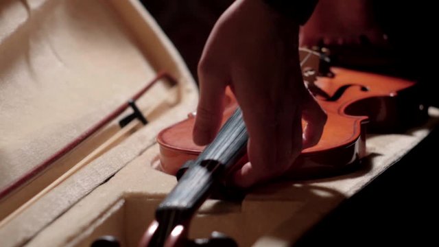 Violinist picking up the violin from hard case, Slow Motion.