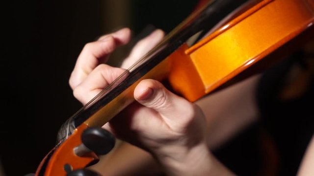 Close up of violinist hands playing the violin. Slow Motion.