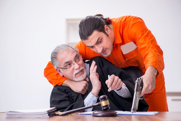 Old male judge meeting with young captive in courthouse