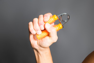 ハンドグリッパーで鍛える男性