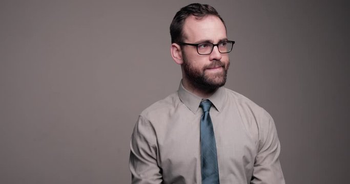 Bearded man uncomfortably adjusted tie and looks around, medium shot