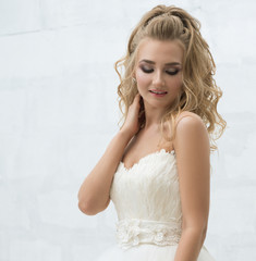 Gorgeous young bride with nice bouquet in studio