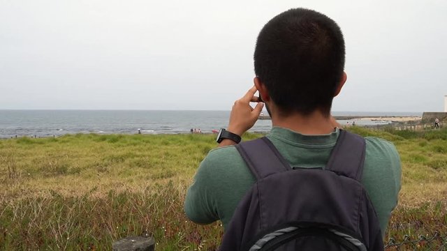 Man Takes photo of the Beach