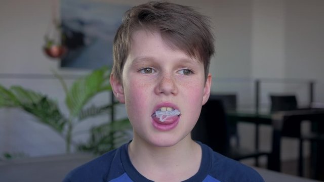 Young handsome teen blowing chewing gum bubble