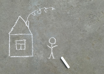 house and man is drawn with chalk on the asphalt. children creativity, summer, housing, family,...
