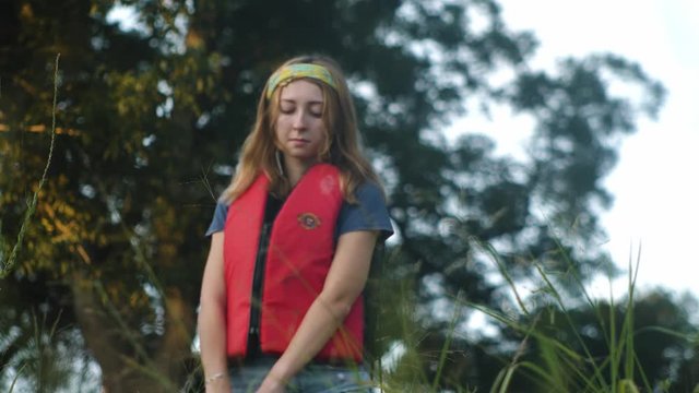 A Woman Carries a Kayak down hill. Long Lens. 4K UHD