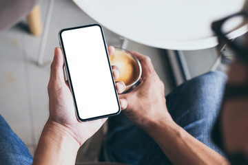 cell phone mockup image blank white screen.man hand holding texting using mobile on desk at coffee shop.background empty space for advertise.work people contact marketing business,technology