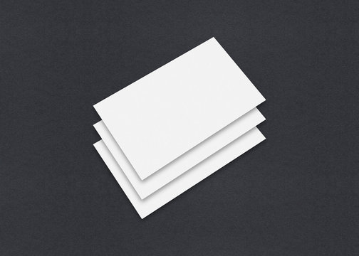 Blank white Business card mockup stacks on grey textured paper background.