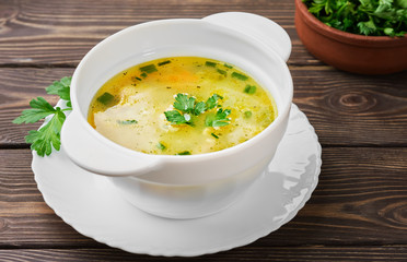Chicken soup on a wooden table, Close-up. Healthy wholesome food. Top view, copy space