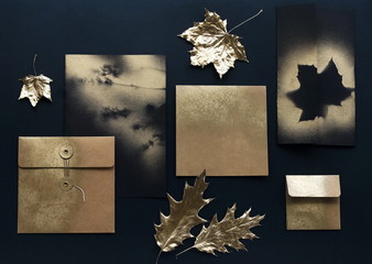 Autumn background. greeting cards mockup template, invitations blank in black, gold colors and fall gold leaves on black textured background. Flat lay, top view, copy space