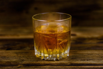 Glass of whiskey on the dark wooden background