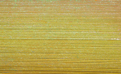 Texture of the metal sheet. Pattern. Metal. A facade made of corrugated sheet metal. Background. Texture. Abstraction. Toned. The corrugated sheet. Yellow metal sheet. Copy space for text.