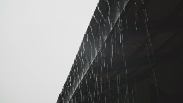 Heavy monsoon rain running off a tiled roof