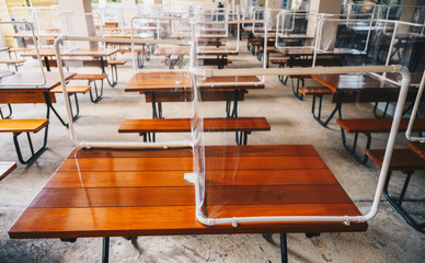 Group of plastic partition (or table shield) setting on table in canteen for reduce and protection the COVID-19 virus spreads in pandemic.