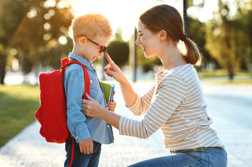 First day at school. mother leads  little child boy in grade
