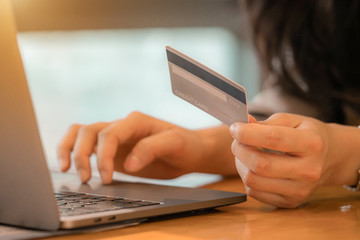 Woman holding mock up credit card and using laptop for shopping online by credit card. Online payment,buy and sell products & services.