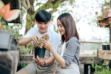 Young couple relax in the garden. They care plant and flower.