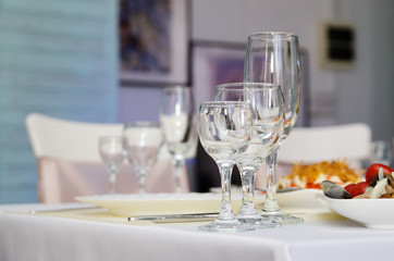 Glass goblets and wine glasses next to a white plate on the banquet table