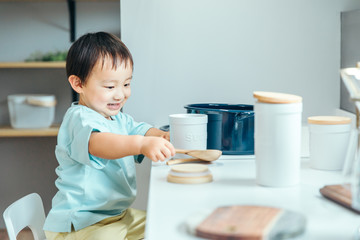 小さい男の子が笑顔で台所で料理している　kids cooking