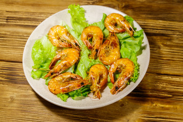 Tasty baked shrimps on a wooden table
