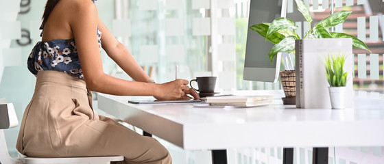 Business woman working with tablet on white table in the office. Side view.
