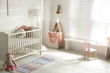 Cute baby room interior with crib and decor elements