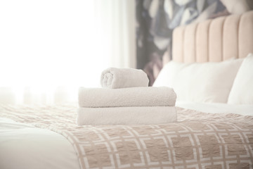 Fototapeta na wymiar Clean white towels on bed at home