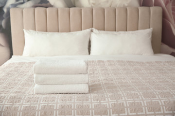 Clean white towels on bed at home