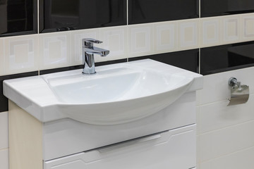 Modern design bathroom sink in a modern residential building or hotel. Modern white bathroom sink with a tap. Selective focus.