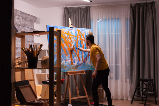 Contemporary painter in studio creating a masterpiece. Modern artwork paint on canvas, creative, contemporary and successful fine art artist drawing masterpiece