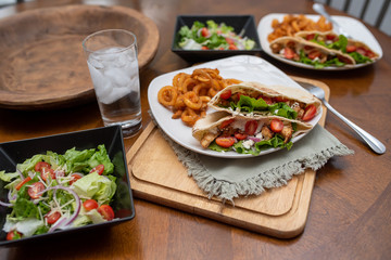 Chicken souvlaki  pita with Tzatziki, Greek style sandwich served with salad and curly fries.  