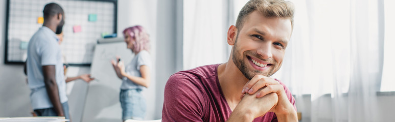 Obraz premium Horizontal crop of young businessman looking at camera in white office