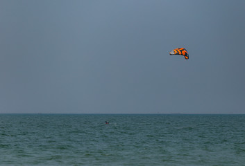A surfboard is surfing on the sea near the long bridge in Pattaya beach of eastern in Thailand on a long holiday.