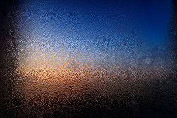 Fototapeta na wymiar Drops of water on a glass in blue in the morning.
