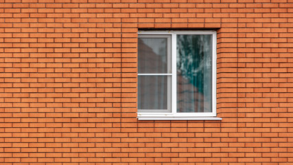 Fototapeta na wymiar Window in a red brick wall as an abstract background