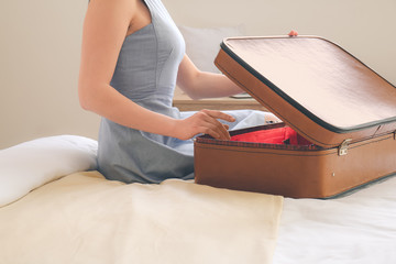 Young woman with suitcase in hotel room