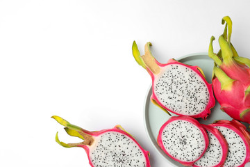 Delicious cut and whole dragon fruits (pitahaya) on white background, top view