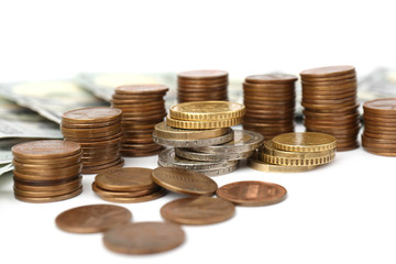 Dollar banknotes and stacks of coins on white background, closeup