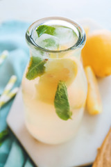 Bottle of fresh lemonade on table, closeup