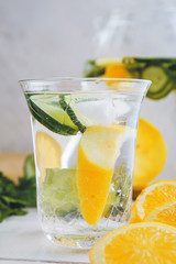 Glass of fresh lemonade with cucumber on table