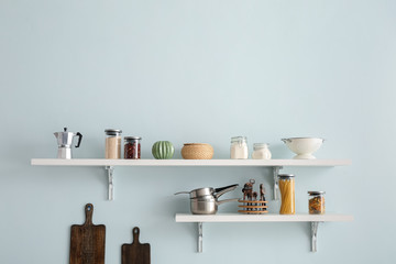 Set of utensils and products on shelves in kitchen