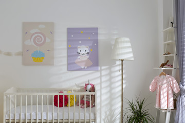 Baby room interior with cute posters and comfortable crib