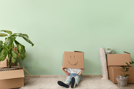 Kid with moving box having fun in new flat