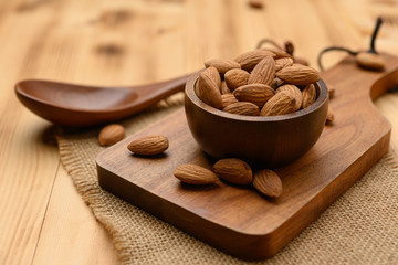 Almonds In Bowl on wood table background with copy space.