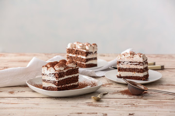 Plates with tasty tiramisu on table