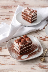 Plates with tasty tiramisu on table