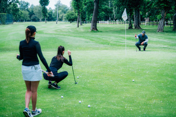 Golf putting. Two young ladies practicing putting