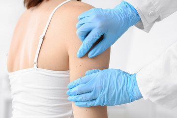 Dermatologist examining patient in clinic